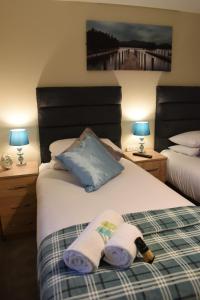 a bedroom with two beds with towels and two lamps at StayNEC Coach House Birmingham - For Company, Contractor & Leisure Stays - NEC, HS2, JLR, Airport in Birmingham