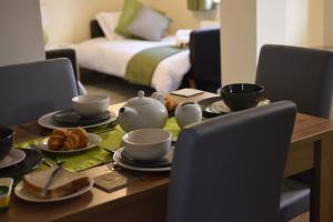 a dining room table with a tea set on it at StayNEC Coach House Birmingham - For Company, Contractor & Leisure Stays - NEC, HS2, JLR, Airport in Birmingham