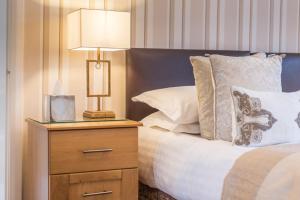 a bed with a night stand with a lamp on it at Grovefield Manor in Poole