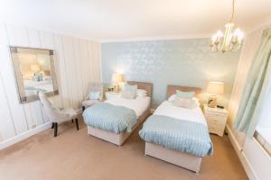 um quarto com 2 camas, um espelho e uma cadeira em Grovefield Manor em Poole