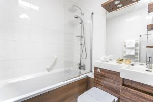 a bathroom with a tub and a toilet and a sink at Grovefield Manor in Poole