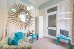 a living room with a couch and a mirror at Grovefield Manor in Poole