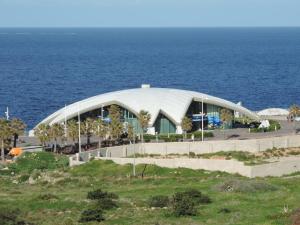 un grande edificio di fronte all'oceano di Qawra Point Holiday Complex a San Pawl il-Baħar