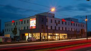 un edificio en una calle por la noche con un semáforo en McDreams Hotel Düsseldorf-City en Düsseldorf