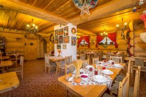 a restaurant with wooden walls and tables and chairs at Willa Joanna in Zakopane