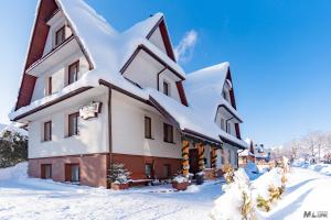 a building covered in snow with snow at Willa Joanna in Zakopane