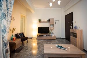 uma sala de estar com um sofá e uma televisão em Blue Ark Athens em Atenas