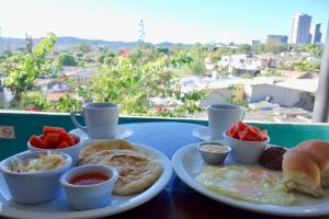 a table with a plate of breakfast food on it at Morrison Hotel San Salvador in San Salvador