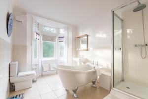 a white bathroom with a tub and a sink at Grovefield Manor in Poole