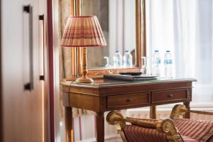 a desk with a lamp and a mirror and a chair at Grovefield Manor in Poole