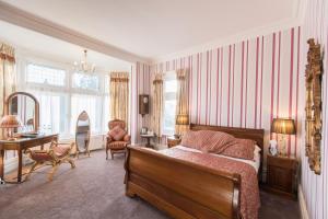 a bedroom with a bed and a desk and a chair at Grovefield Manor in Poole