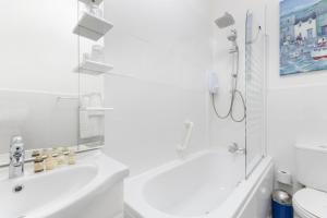 a white bathroom with a tub and a shower at Grovefield Manor in Poole
