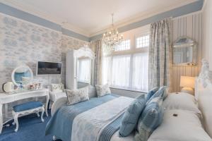 a bedroom with two beds and a desk and a mirror at Grovefield Manor in Poole