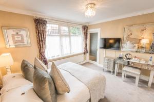 a bedroom with a large bed and a television at Grovefield Manor in Poole
