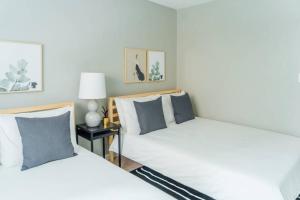 1BR Stylish Apartment, Perfect for Getaway - Oakdale 201 في شيكاغو: سريرين يجلسون بجانب بعض في غرفة النوم
