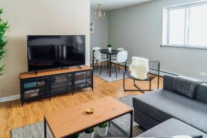 1BR Stylish Apartment, Perfect for Getaway - Oakdale 201 في شيكاغو: غرفة معيشة مع أريكة وتلفزيون