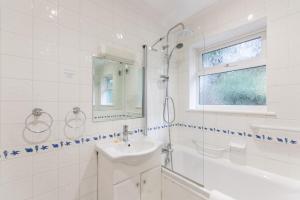 a white bathroom with a sink and a shower at Grovefield Manor in Poole