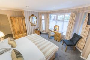 a bedroom with a bed and a desk and a chair at Grovefield Manor in Poole