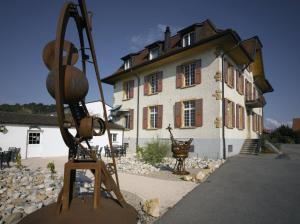 ein Gebäude mit einer Statue davor in der Unterkunft Hotel de la Gare in Sugiez