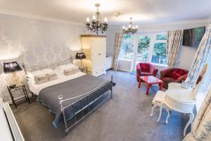 a bedroom with a bed and a desk and chairs at Grovefield Manor in Poole