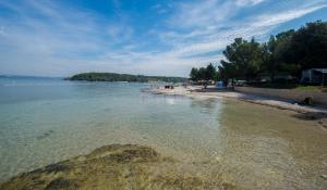 a view of a beach with people in the water at Lumbre Apartment in Vabriga