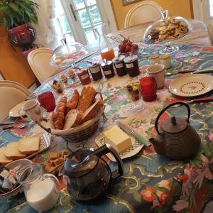 a table topped with a table with bread and tea at La table de Pierre in Lussas-et-Nontronneau