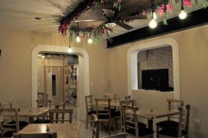 a dining room with tables and chairs and a tv at Hotel Virreyes in Mérida