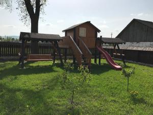 a playground with a slide in a yard at Pensiunea Dany - Crys in Zvoriştea