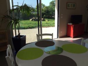 una habitación con una mesa y una maceta en Les Écorchoux c'est chou, en Tossiat