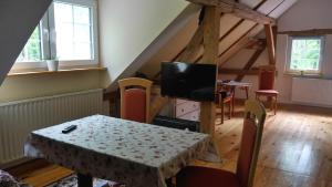 a dining room with a table and a television in a attic at Wjažka in Guhrow