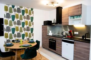 a kitchen with a wooden table and a kitchen counter at ILodge Secondia in Chessy