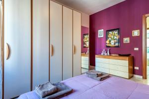 een paarse slaapkamer met een bed en een wastafel bij Apartment Angelo Emo 69 in Rome