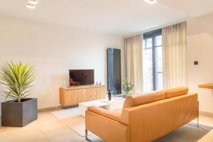 Guesthouse De Vliere في Beerse: غرفة معيشة مع أريكة وتلفزيون