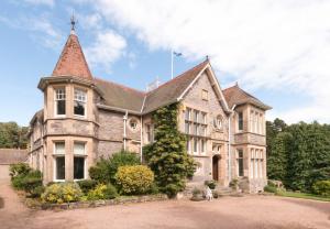 a large stone house with a turret at Firlands Lodge in Forres