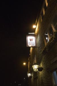 um sinal na lateral de um edifício à noite em The Bulls Head em Glossop