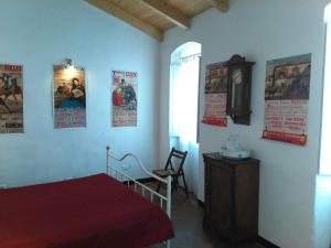 Un dormitorio con una cama y un reloj y carteles en la pared. en Lovely renovated apartment near Dolcedo, en Dolcedo