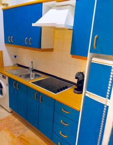 een blauwe keuken met een wastafel en een fornuis bij Ritual Sevilla Suite Alameda 5 in Sevilla