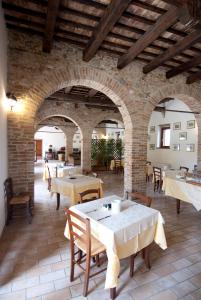 a restaurant with tables and chairs and a brick wall at Agriturismo Villa Irelli in Castellalto