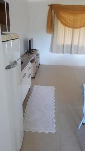 a white kitchen with a bed and a white rug at Apto Studio in Nova Petrópolis