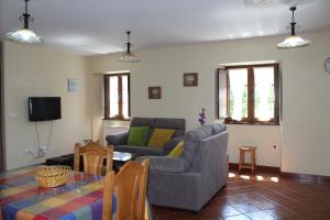 a living room with a couch and a table and chairs at Apartamentos Casa Cerolleiro in Castropol