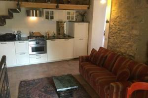 a living room with a couch and a kitchen at Lovely renovated apartment near Dolcedo in Dolcedo
