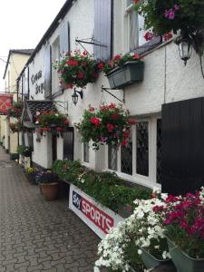 a street with flowers on the side of a building at The Crosskeys Inn in Usk