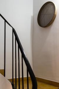 a clock on a wall next to a staircase at Casa Rosalía in Ibi