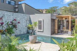 a home with a swimming pool and a house at Zen Garden Tamarindo - Adults Only in Tamarindo