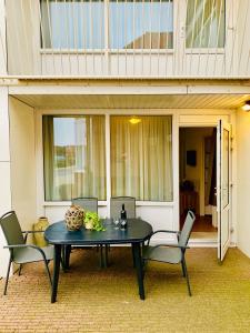 a black table with chairs and a bowl on it at Appartement aan het strand De Zeemeermin in Zoutelande