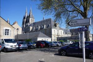 un estacionamiento con autos estacionados frente a un edificio en Appartement centre historique, en Blois