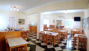 restauracja ze stołami i krzesłami oraz kuchnia w obiekcie Blue Bay Villas w mieście Kamari