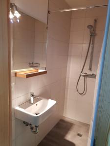 a white bathroom with a sink and a shower at Ferienwohnung ,,Zum Posthaus" in Kolkwitz