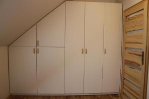 Zimmer mit weißen Schränken und einem Schrank in der Unterkunft Apartament Zielone Tarasy - PCK 34 in Jelenia Góra