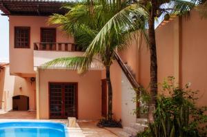 a house with a swimming pool and palm trees at Hotel Alta Vista in Canoa Quebrada